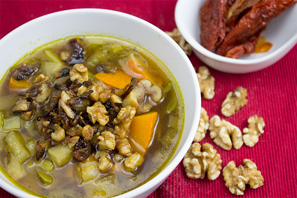 Klare Kürbissuppe mit Maroni und einem crunchigem Topping aus gebratenen, getrockneten Tomaten, gehackten Walnüssen und Chamipgnons.